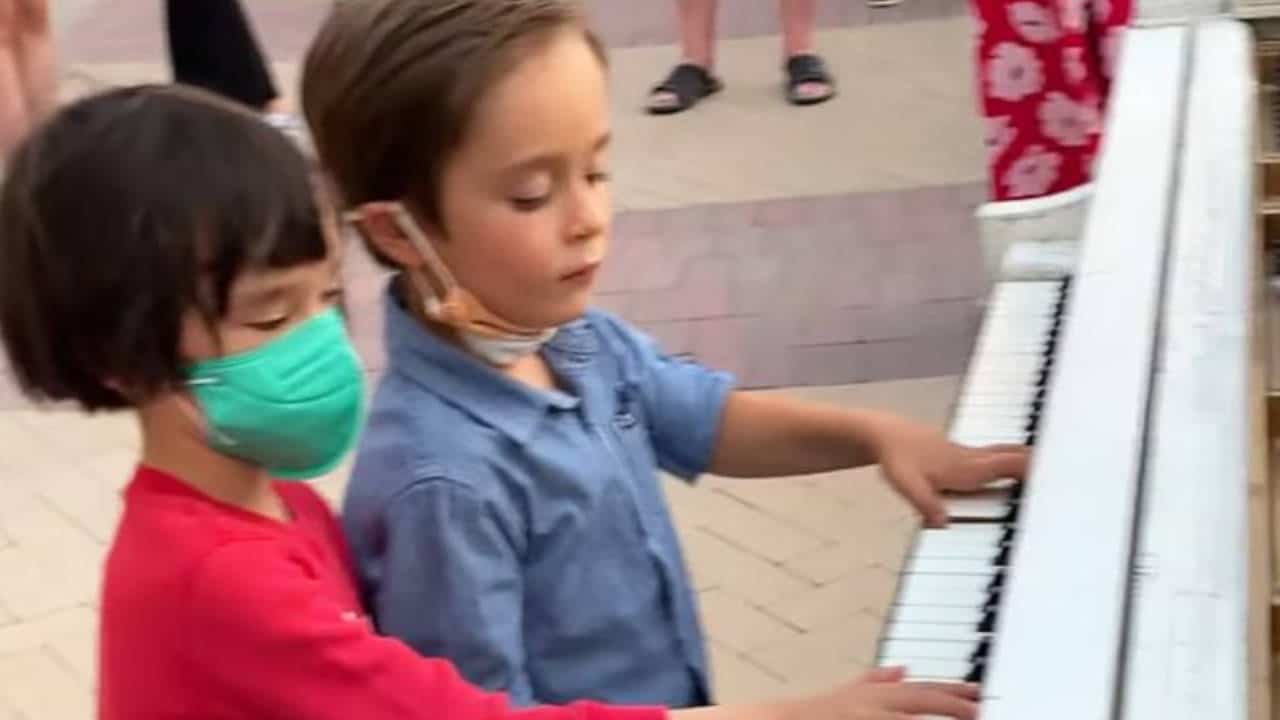 Due bambini di sei anni eseguono splendidamente un pezzo per pianoforte