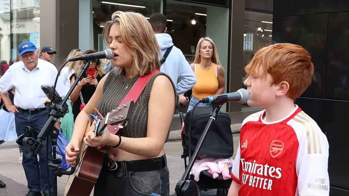 un ragazzino duetta con l'artista di strada, cantando "Hallelujah"