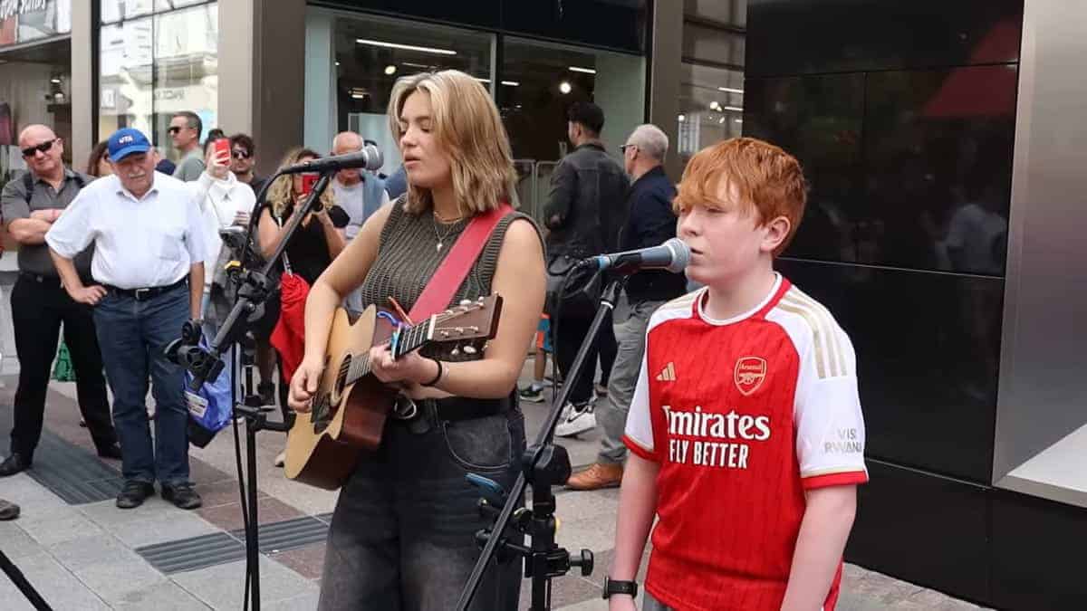 un ragazzino duetta con l'artista di strada, cantando "Hallelujah"