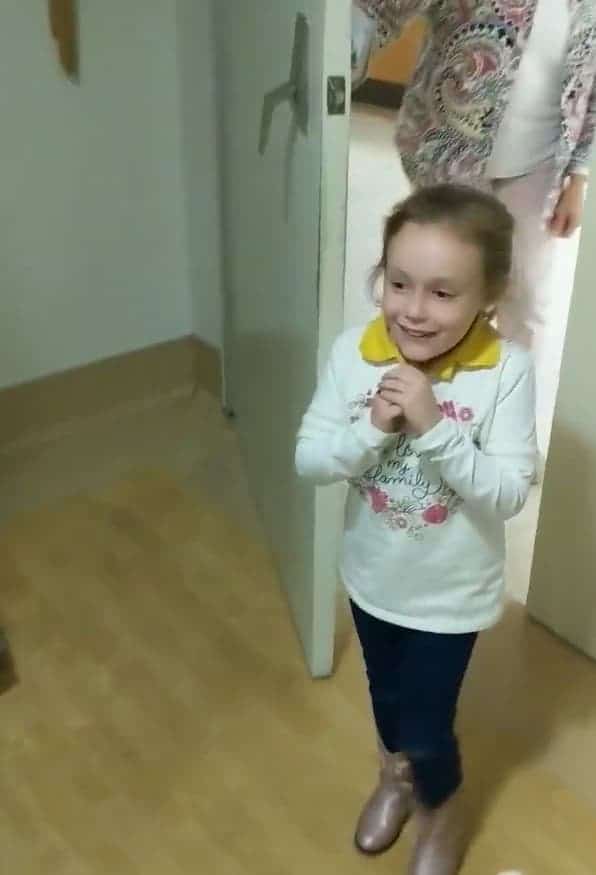 Una bambina non trattiene le lacrime di gioia quando vede la sorellina appena nata.