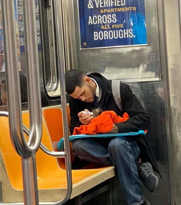 Uomo nella metro allatta una gattina con il biberon