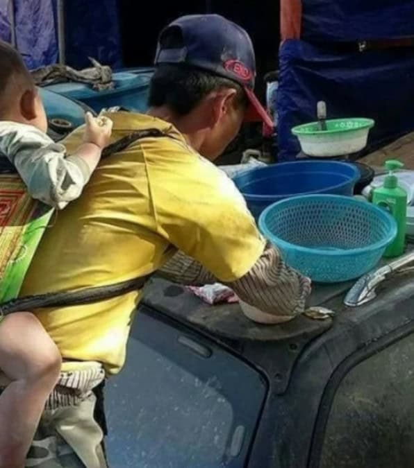 La commovente storia di un padre vietnamita che lavora con il figlio legato alla schiena